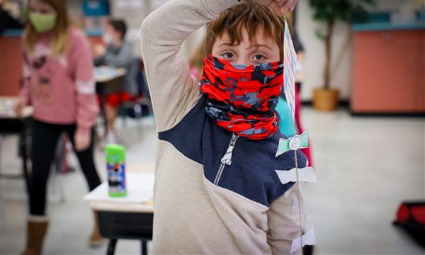 Boy holds up paper kite